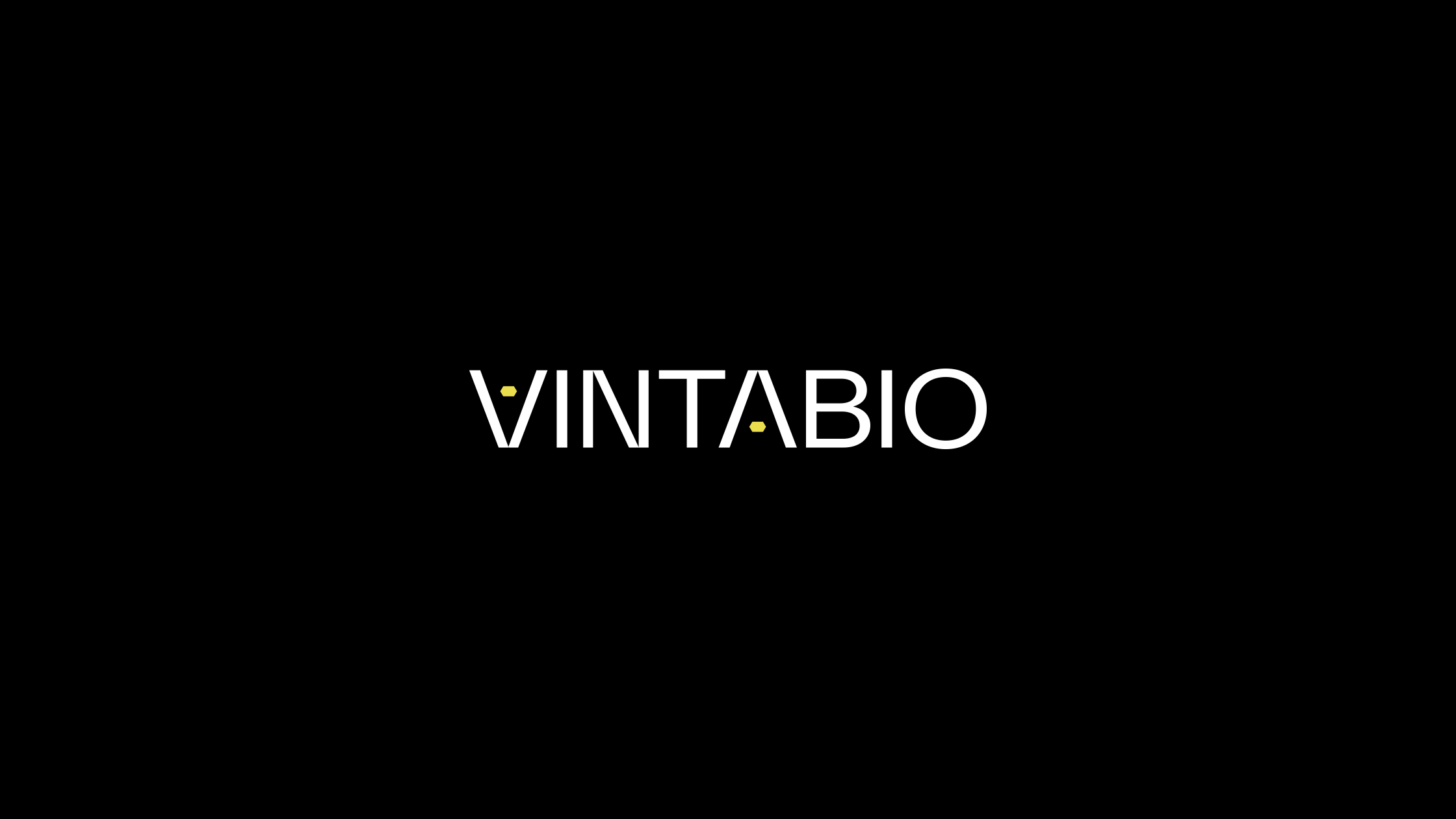 VintaBio logo by Igawa Design, featuring minimalist typography and yellow hex symbols symbolizing DNA and the company’s innovative platform, set against a bold black background to convey boldness and precision.